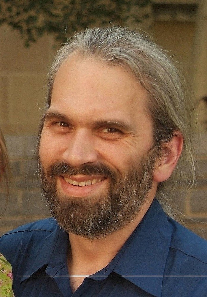 Photo of Bryan Gunsch, a middle aged man with graying hair and a beard and mustache.